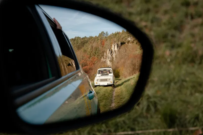 Blick durch den Seitenspiegel auf einen historischen Renault 4