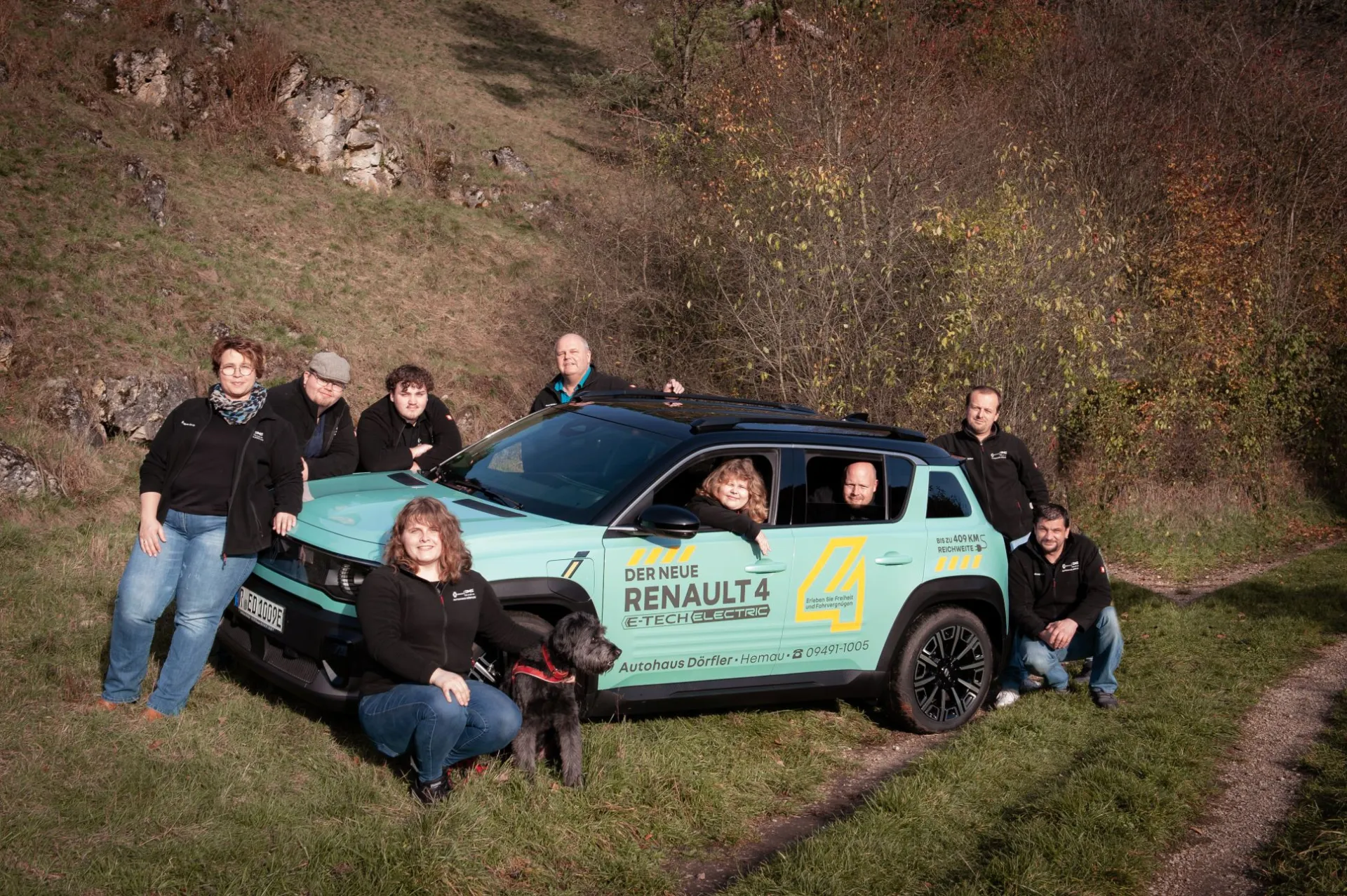 Das Team des Autohauses Dörfler mit Hund am neuen Renault 4 E-Tech Electric